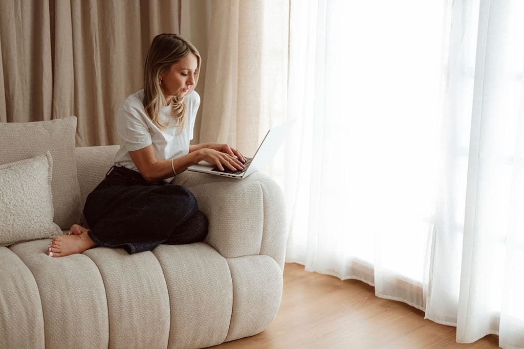 Anna Cush, Founder of Evoke Advisory, working from a laptop in a softly lit room